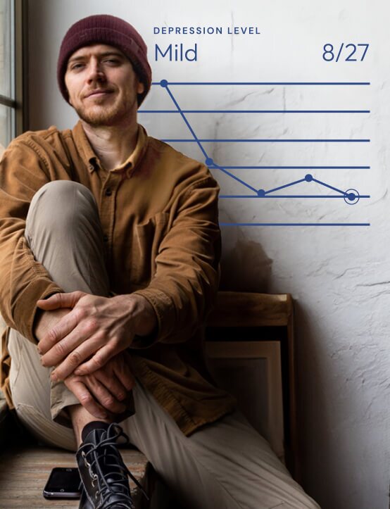 man sitting next to a window and smiling